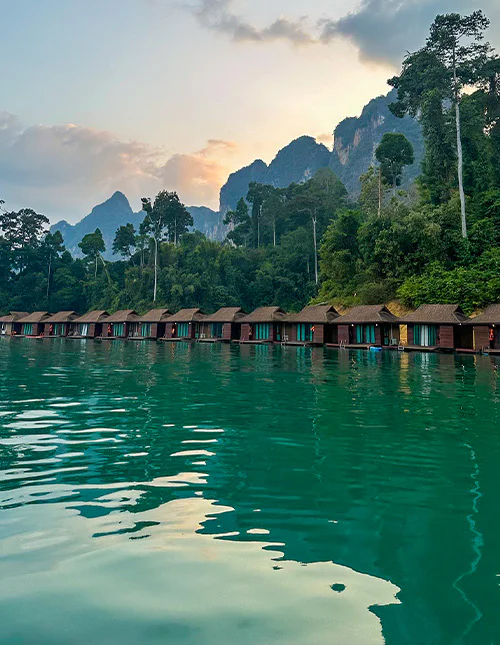 Flytande bungalower på en smaragdgrön sjö i Thailand