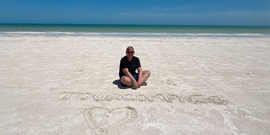 Tom sitter i sanden på Isla Holbox i Mexiko.