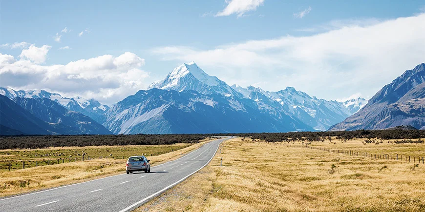 Bil kører i smukke landskaber i New Zealand