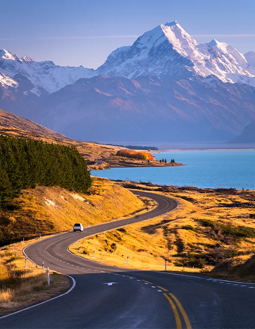 Mount Cook tornar upp sig över det blå vattnet i Lake Pukaki på Nya Zeelands Sydön.