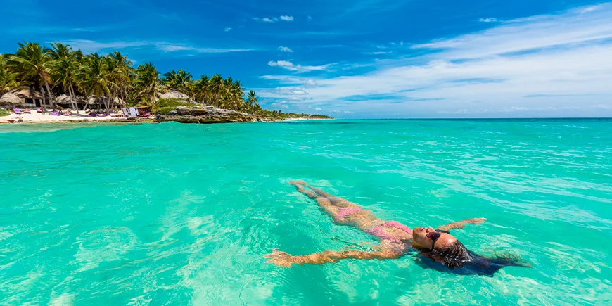 Kvinna i vattnet vid Tulum Beach