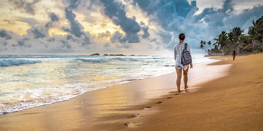 Kvinna går på stranden i Sri Lanka