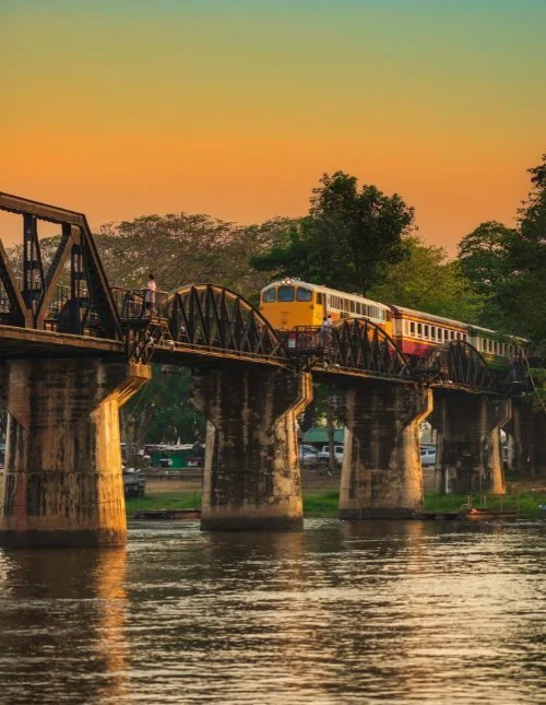Tåg på bron över floden Kwai i Kanchanaburi, Thailand