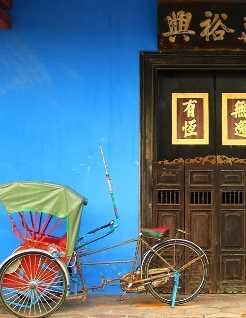 Blå kinesisk husdörr med rickshaw i Singapore