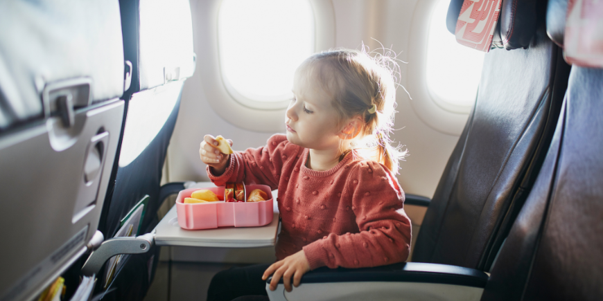Barn äter snacks på flyget