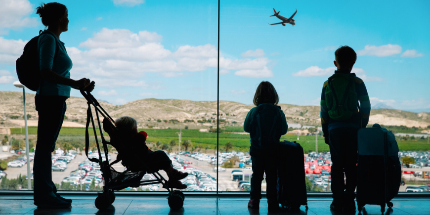 Mamma väntar med barn på flygplatsen