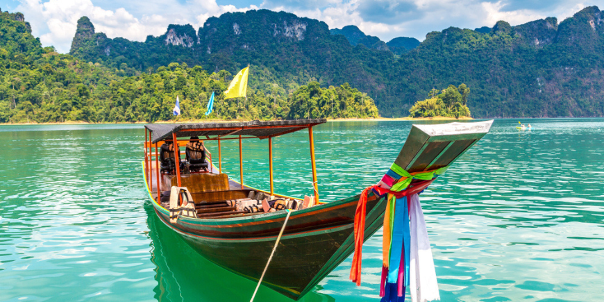 Traditionell longtail-båt med vacker utsikt över landskapet i Ratchaprapha Dam vid Khao Sok nationalpark, Surat Thani-provinsen, Thailand.