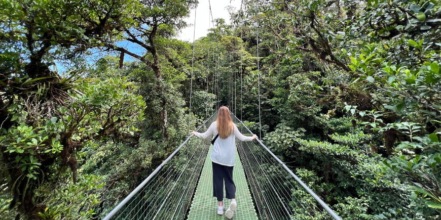 Kvinna står på hängande broar i Monteverde, Costa Rica