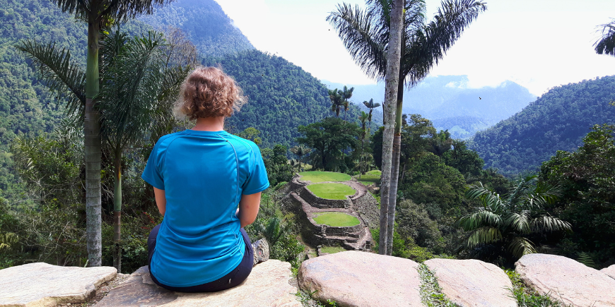 Kvinna sitter och tittar på La Ciudad Perdida i Colombia