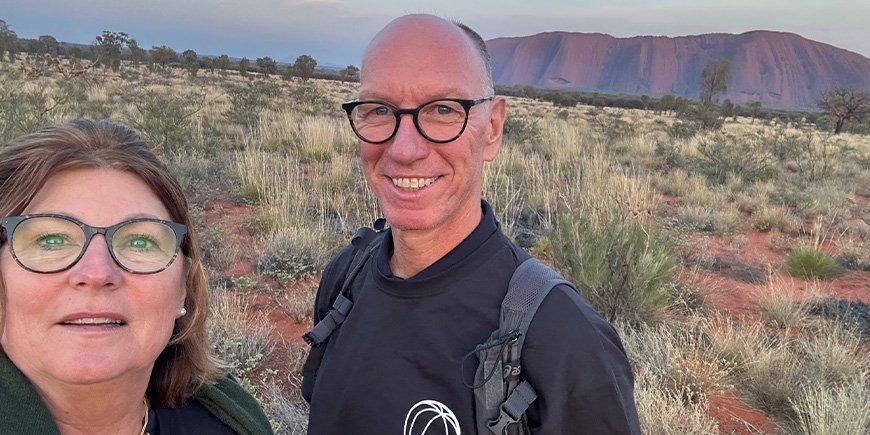 Beate och hennes man tar ett foto framför Uluru i Australien