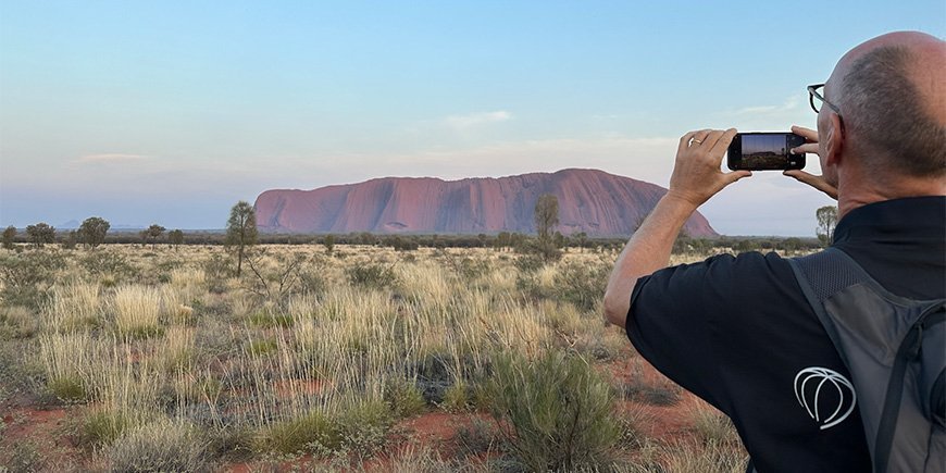 Maken tar ett foto av Uluru i Australien