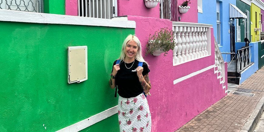 Cat står framför de färgglada husen i Bo-Kaap i Kapstaden