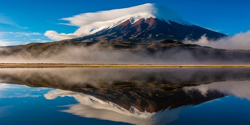 Vulkanen Cotopaxi i Ecuador speglar sig i vattnet 