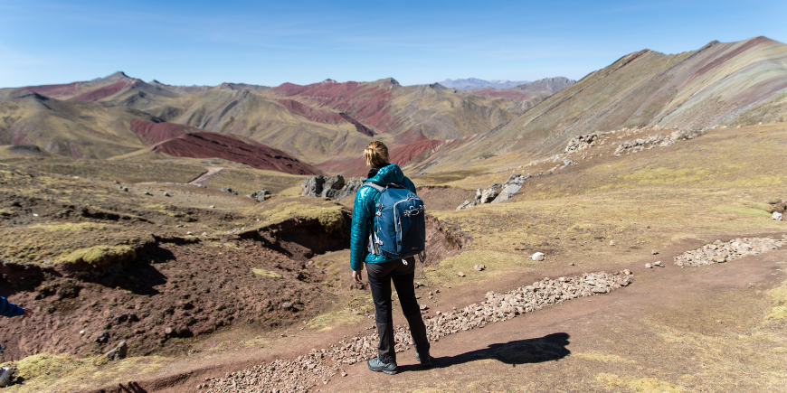 Kvinna vandrar vid Rainbow Mountain i Peru