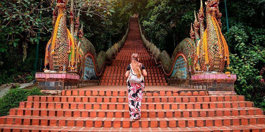Kvinna klättrar uppför trapporna vid Doi Suthep-templet i Chiang Mai, Thailand.