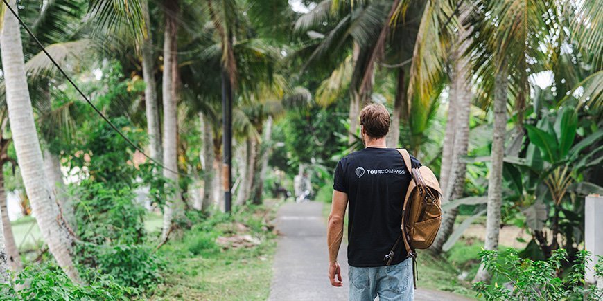 Man promenerar under palmer på Bali, Indonesien
