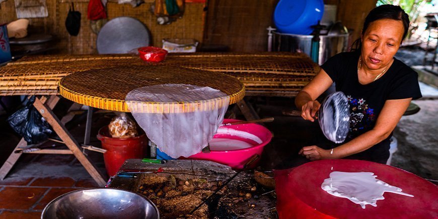 Vietnamesiska kvinnor gör rispapper i Vietnam