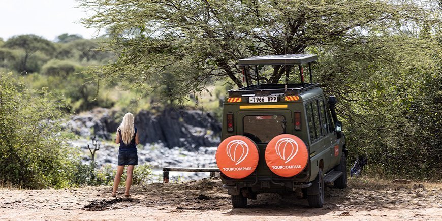 Kvinna och TourCompass Jeep i Tanzania