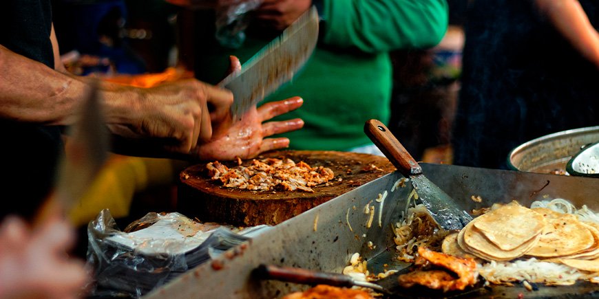 Kött förbereds för Tacos vid ett matstånd i Mexico City