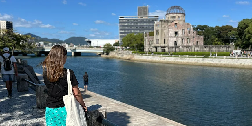 Kvinna som tittar på atombombsdomen i Hiroshima, Japan