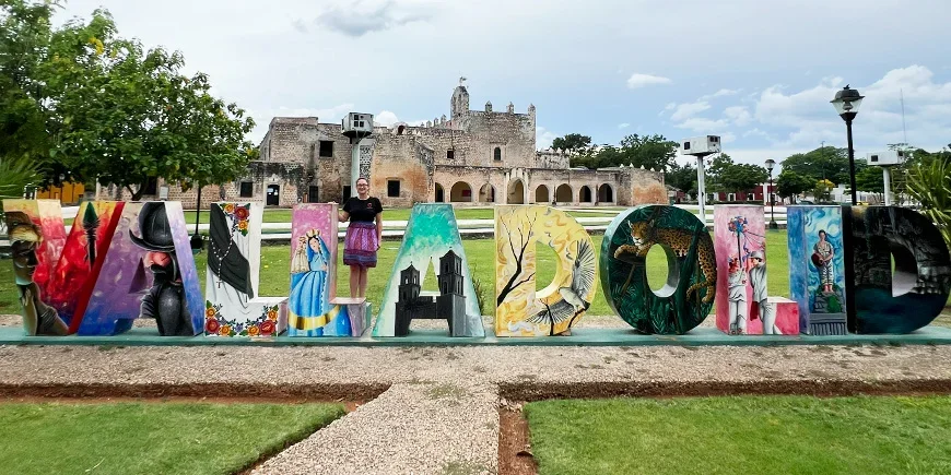 Chrismarie står framför en Valladolid-skylt i Mexiko