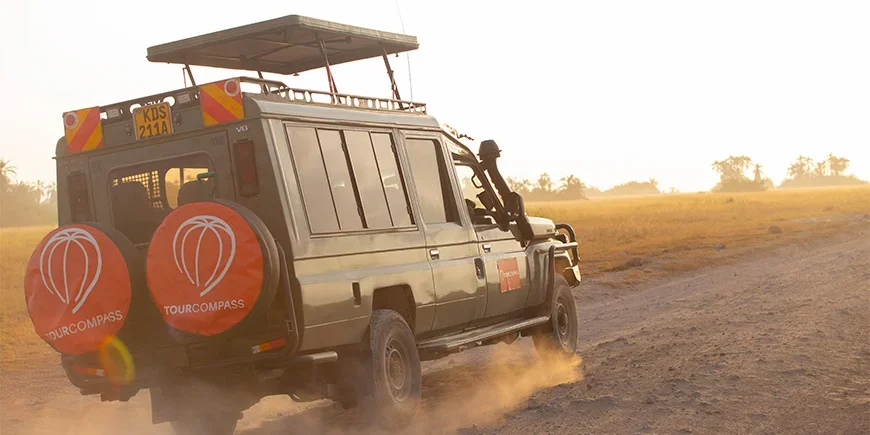 Jeep med TourCompass-logotyp kör på savannen i Kenya