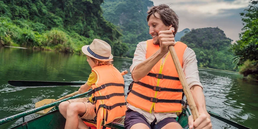 Far och son seglar vid Ninh Binh i Vietnam