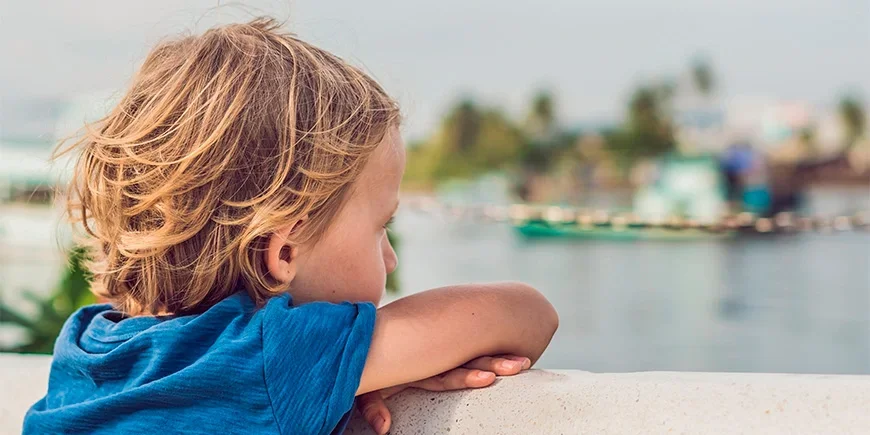Pojke tittar på båtar i vattnet vid Phu Quoc i Vietnam