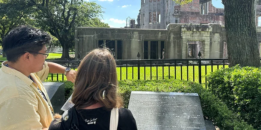 Manlig japansk guide med kvinnlig turist i Hiroshima i Japan