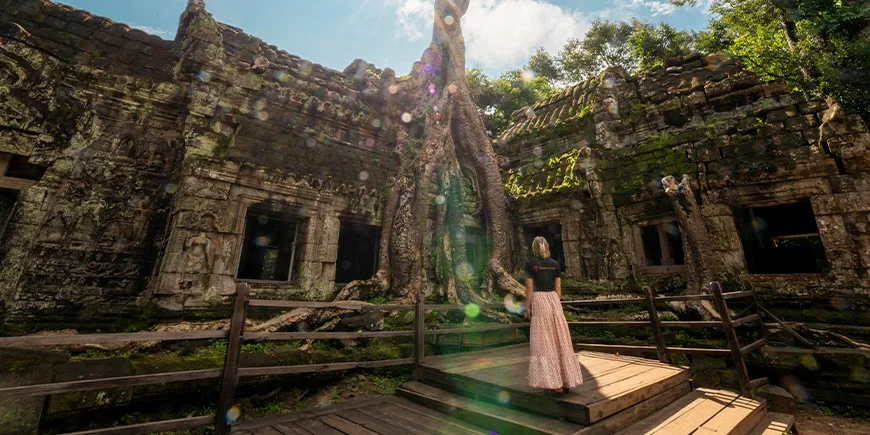 Kvinna i TourCompass-tshirt står i Angkor i Kambodja