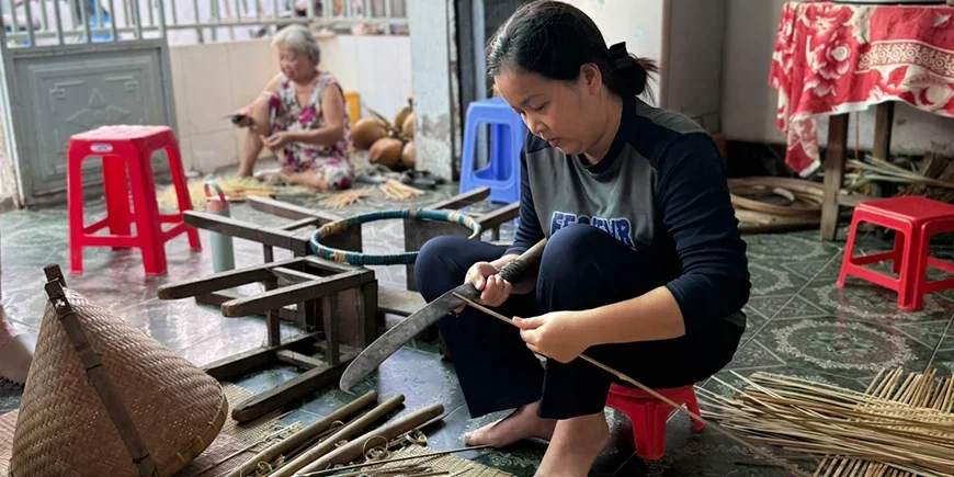 Vietnamesisk kvinna som skapar saker av kokosnöt