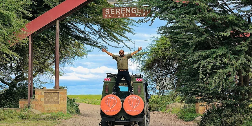 Safari guide Madeal framför ingången till Serengeti