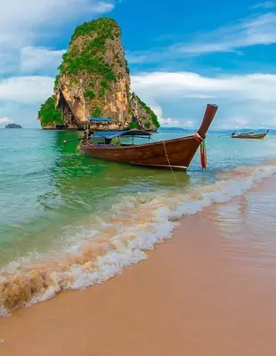 Longtailbåtar under blå himmel på stranden i Krabi, Thailand