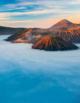 Vulkanberget Bromo, omgivet av morgondimma, vid soluppgång i östra Java i Indonesien
