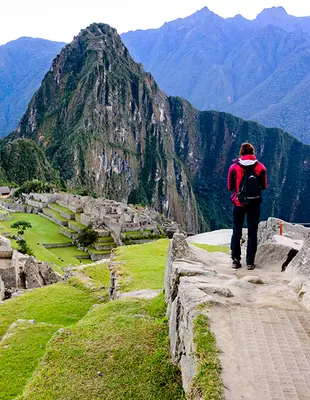 Turist vid inkaruinen Machu Picchu vid soluppgång